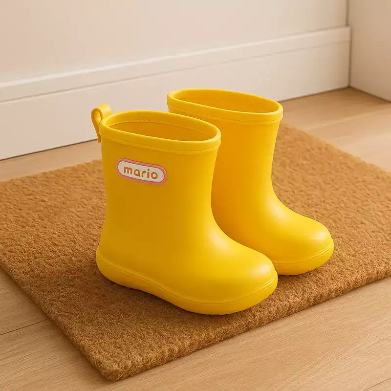 bottes de pluie fille jaunes posées proprement sur un paillasson