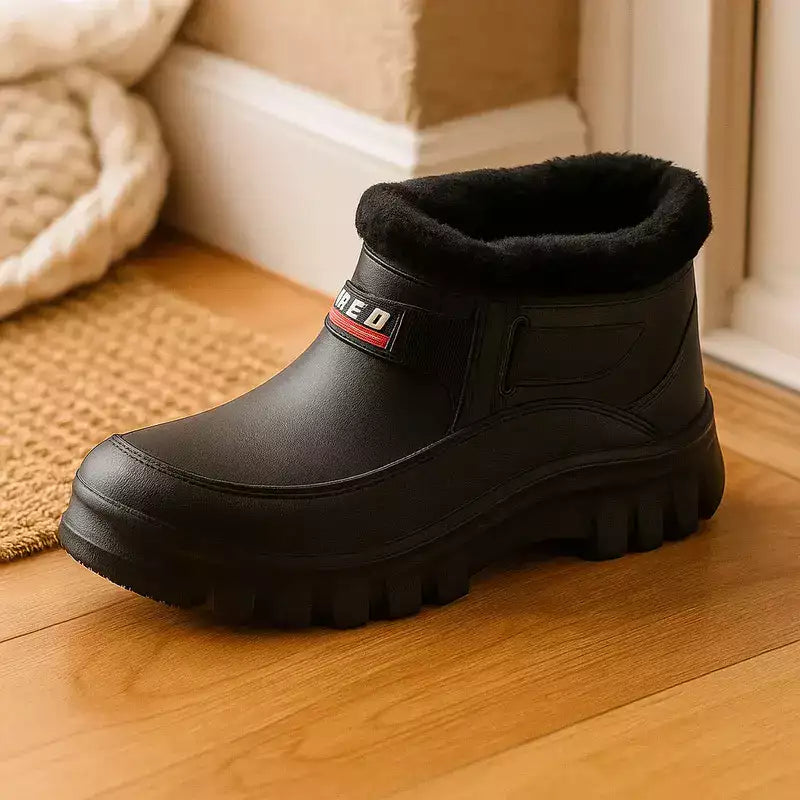 bottes fourrées noires posées près d'un tapis à l'entrée d'une maison