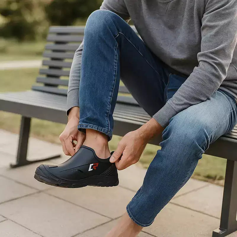homme assis sur un banc moderne en train d'enfiler facilement ses bottes de pluie noires